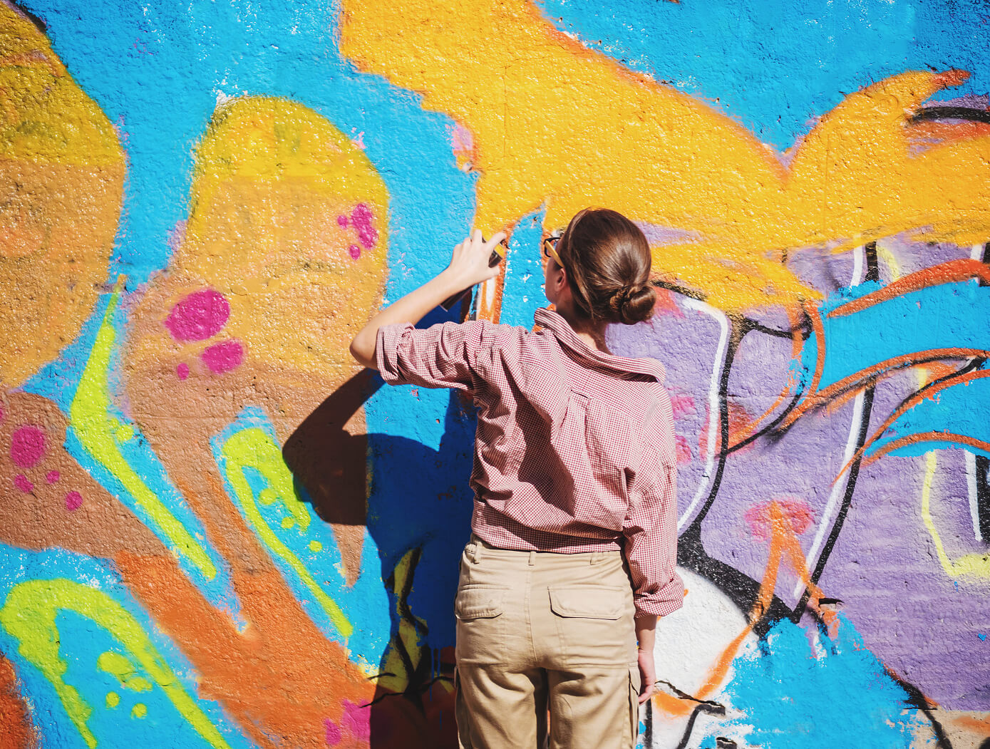 Person spray-painting art on a wall